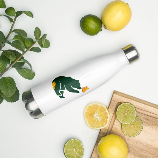 The 17 oz Beary Cool Water Bottle, with the Petals & Paws green bear logo graphic laying on its side amidst citrus fruit, herbs and a cutting board.