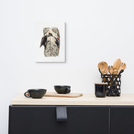 Gallery-wrapped canvas of Coaxing Courage, about Pileated Woodpecker parenting, hanging on a wall with surrounding livingroom furnishings. Illustrated by Suzanne Matheson, 2017.