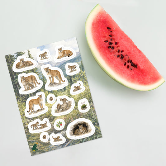 A sheet of kiss-cut stickers featuring illustrated mountain lion mothers and cubs set against a scene in the foothills of the Rocky Mountains, and placed next to a slice of watermelon.