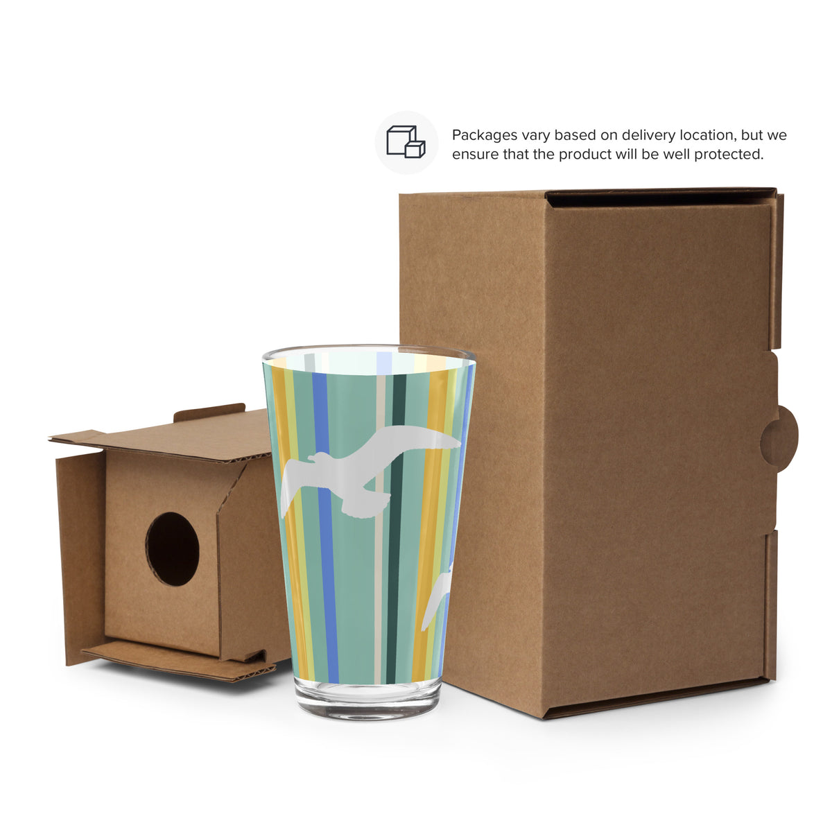 Cardboard packaging surrounds a Petals & Paws Cove Pint Glass. Text says, "Packages vary based on delivery location, but we ensure that the product will be well protected."