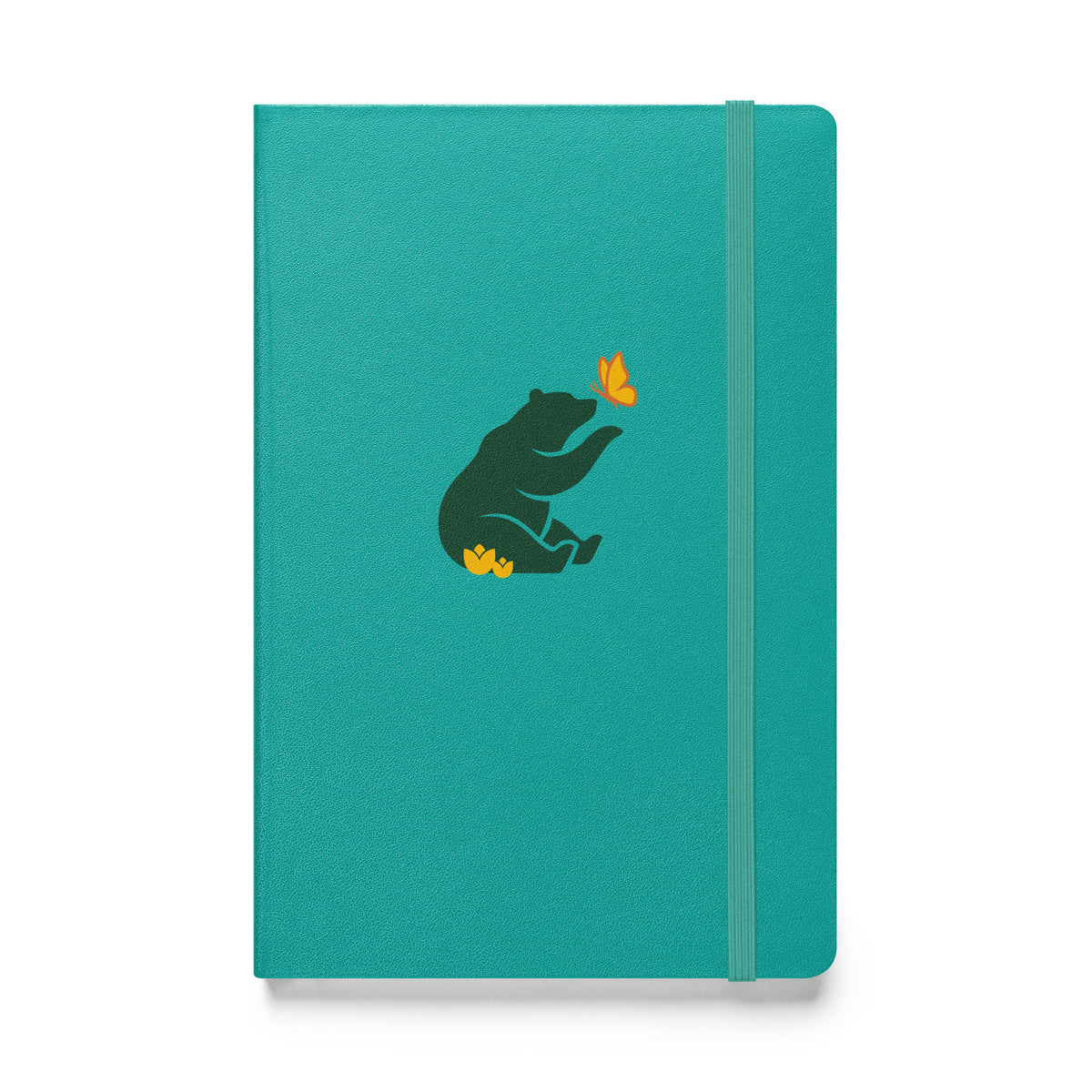 Flat-lay of turquoise notebook with green Petals & Paws bear graphic, sitting in yellow flowers with paw extended to yellow and orange butterfly.