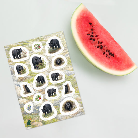 A sheet of kiss-cut stickers featuring illustrated black bears foraging, with a background of rocky mountain icefields terrain, placed next to a slice of watermelon.