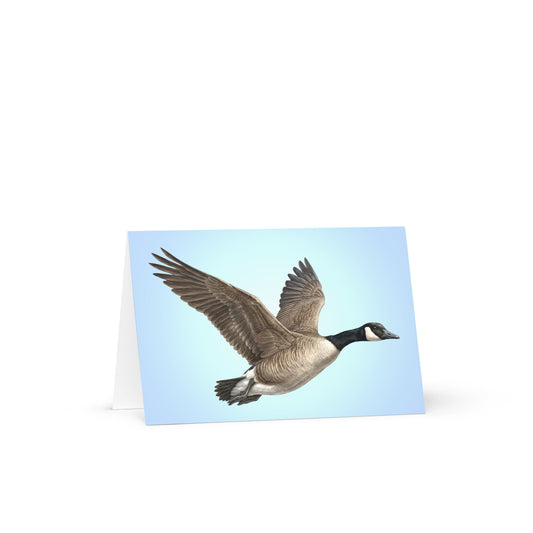 Product mockup of the Canada Goose Greeting Card, standing open, with a realistic flying goose against a clear blue sky.