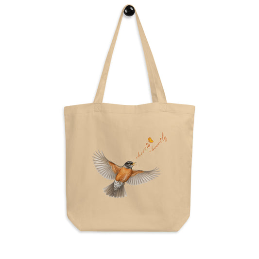 Product mockup of the Cheerily Robin Eco Tote Bag, with a flying robin, singing, "cheerio cheerily" set against the ecru 100% organic cotton.  Print is on one side. The Petals & Paws orange and yellow butterfly accents the songster's text.