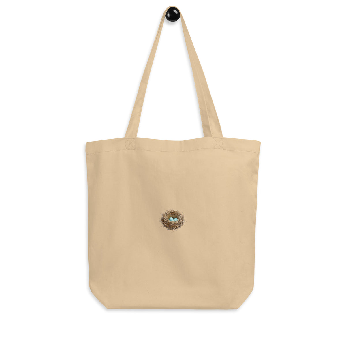 Product mockup of the Cheerily Robin with Nest Eco Tote Bag, revealing a beautiful robins nest with three robin-blue eggs inside, set against the ecru 100% organic cotton.  Two-side printed. 