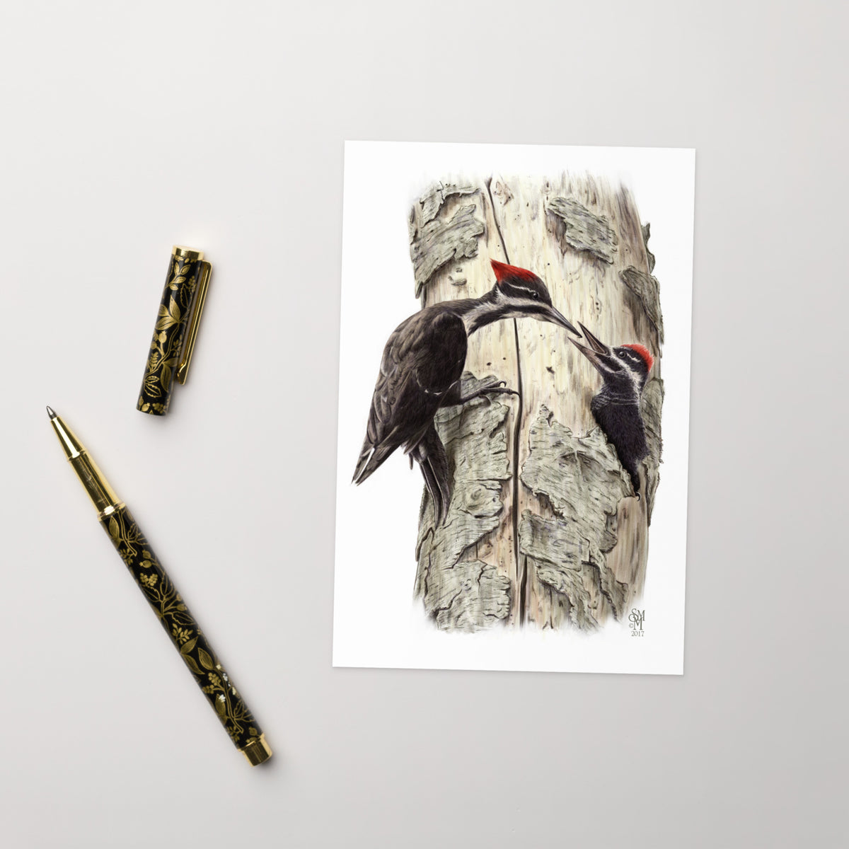 Product mockup of the Coaxing Courage Greeting Card, shown with a fancy pen and cap on a beige surface.