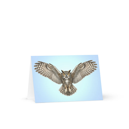 Product mockup of the Great Horned Owl Greeting Card, standing open, with a realistic flying owl against a clear blue sky.