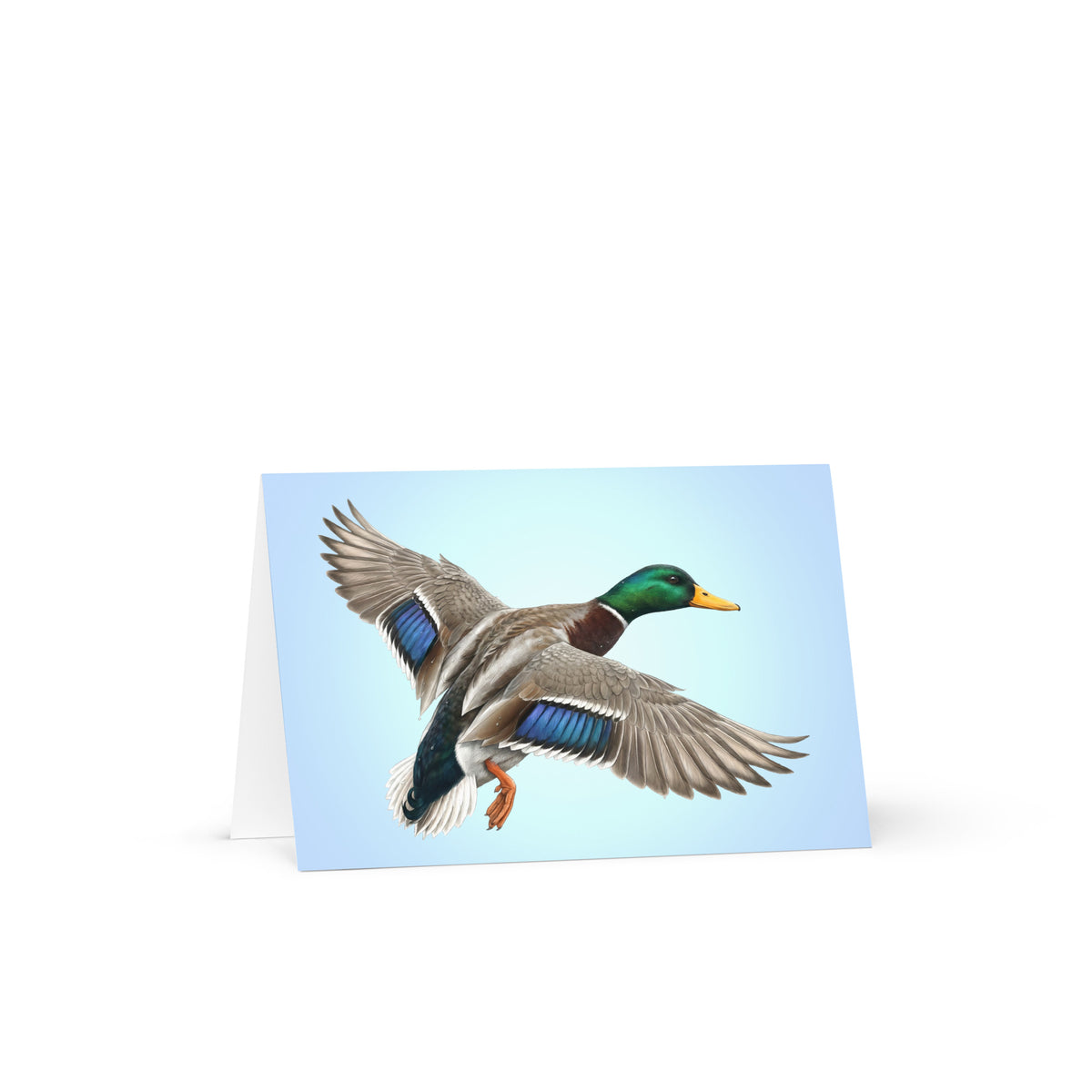 Product mockup of the Mallard Duck Greeting Card, standing open, with a realistic flying duck against a clear blue sky.
