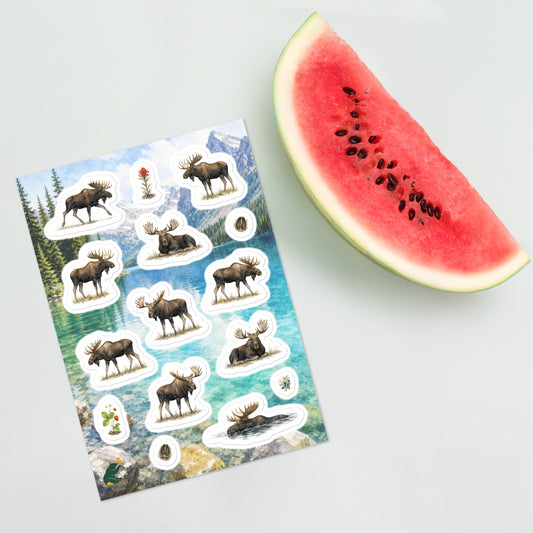 A sheet of kiss-cut stickers featuring illustrated mature bull moose, set against a Rocky Mountain lake scene, and placed next to a slice of watermelon. 