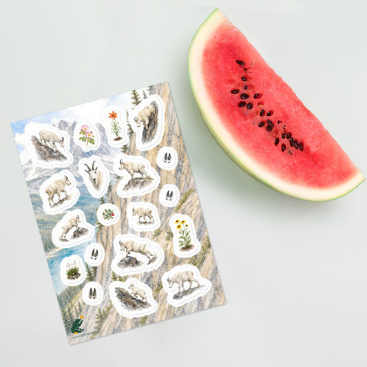 A sheet of kiss-cut stickers featuring Rocky Mountain landscape and mountain goat illustrations, placed next to a slice of watermelon.