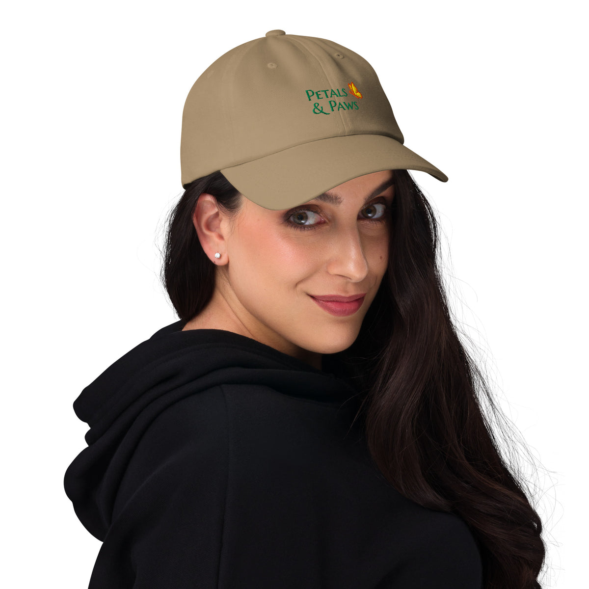 A woman with dark brown hair wearing the khaki Petals & Paws Classic Dad Hat. Front view.