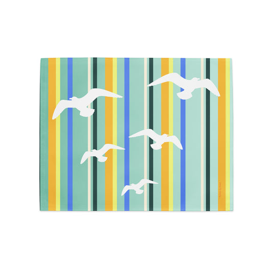 Product mockup of a Petals & Paws Cove Placemat, featuring seagull design with teal striped pattern.