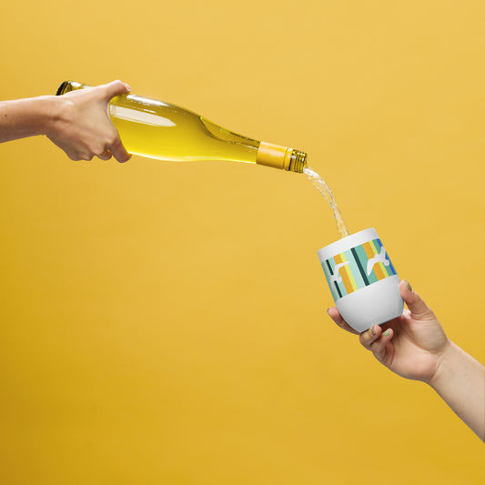 In-action mockup of Petals & Paws Cove Wine Tumbler, featuring seagull design with teal striped pattern. The hand of one person holds a bottle of wine, pouring it into the tumbler held by another person's hand. Background is an orange glow.