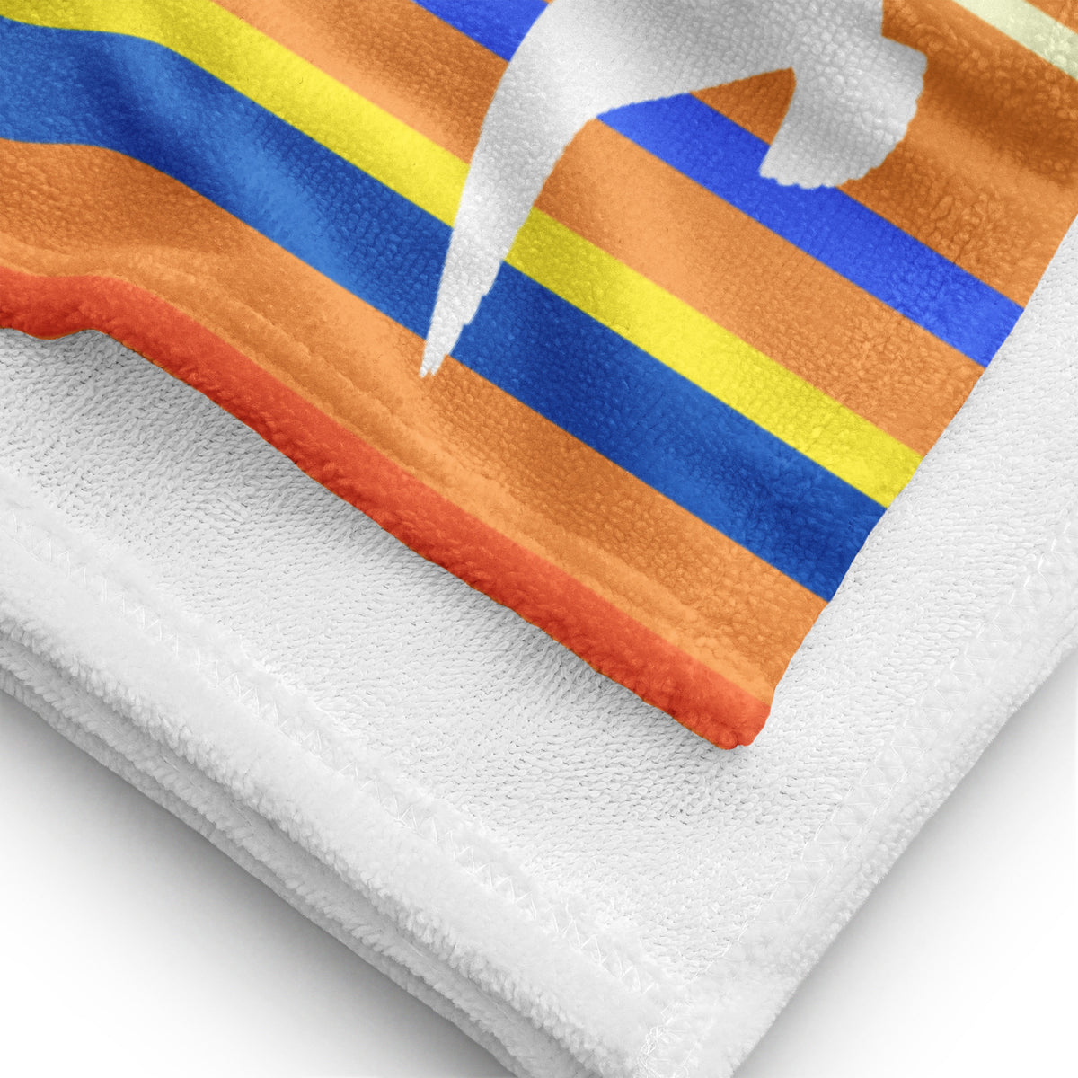 A close-up view of folded 30 x 60" Petals & Paws Drift Beach Towel, revealing the print of seagull design with orange striped pattern on terry fabric and the white back surface.