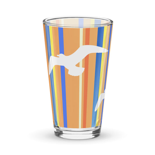 Product mockup of 16 oz Petals & Paws Drift Pint Glass, featuring seagull design with orange striped pattern.