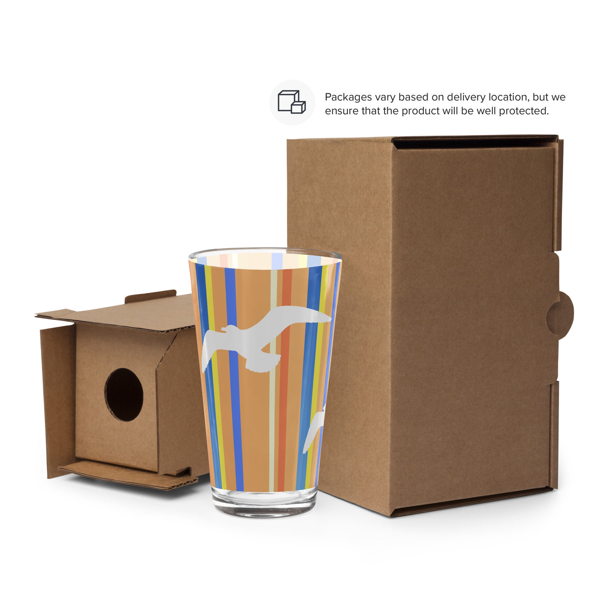 Cardboard packaging surrounds a Petals & Paws Drift Pint Glass. Text says, "Packages vary based on delivery location, but we ensure that the product will be well protected."