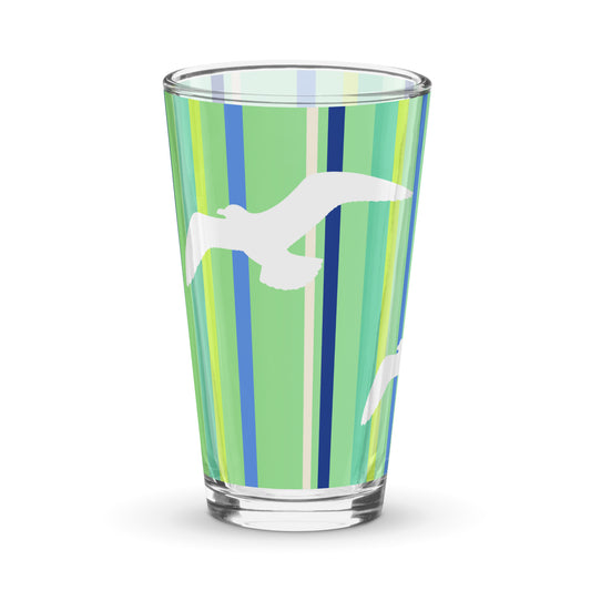 Product mockup of 16 oz Petals & Paws Harbour Pint Glass, featuring seagull design with green striped pattern.
