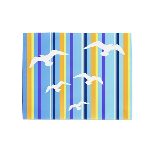 Product mockup of a Petals & Paws Shoreline Placemat, featuring seagull design with blue striped pattern.