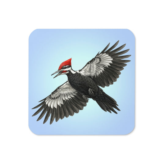 Product mockup of the front of Pileated Woodpecker Coaster cork-backed, square coaster.  Design is a woodpecker is flying against a clear blue sky.