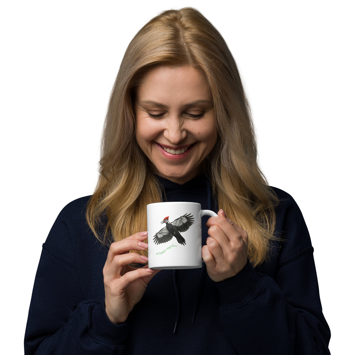 A woman holding her So Happy Together 11oz Pileated Woodpecker mug.  The white mug stands out against a dark sweater.