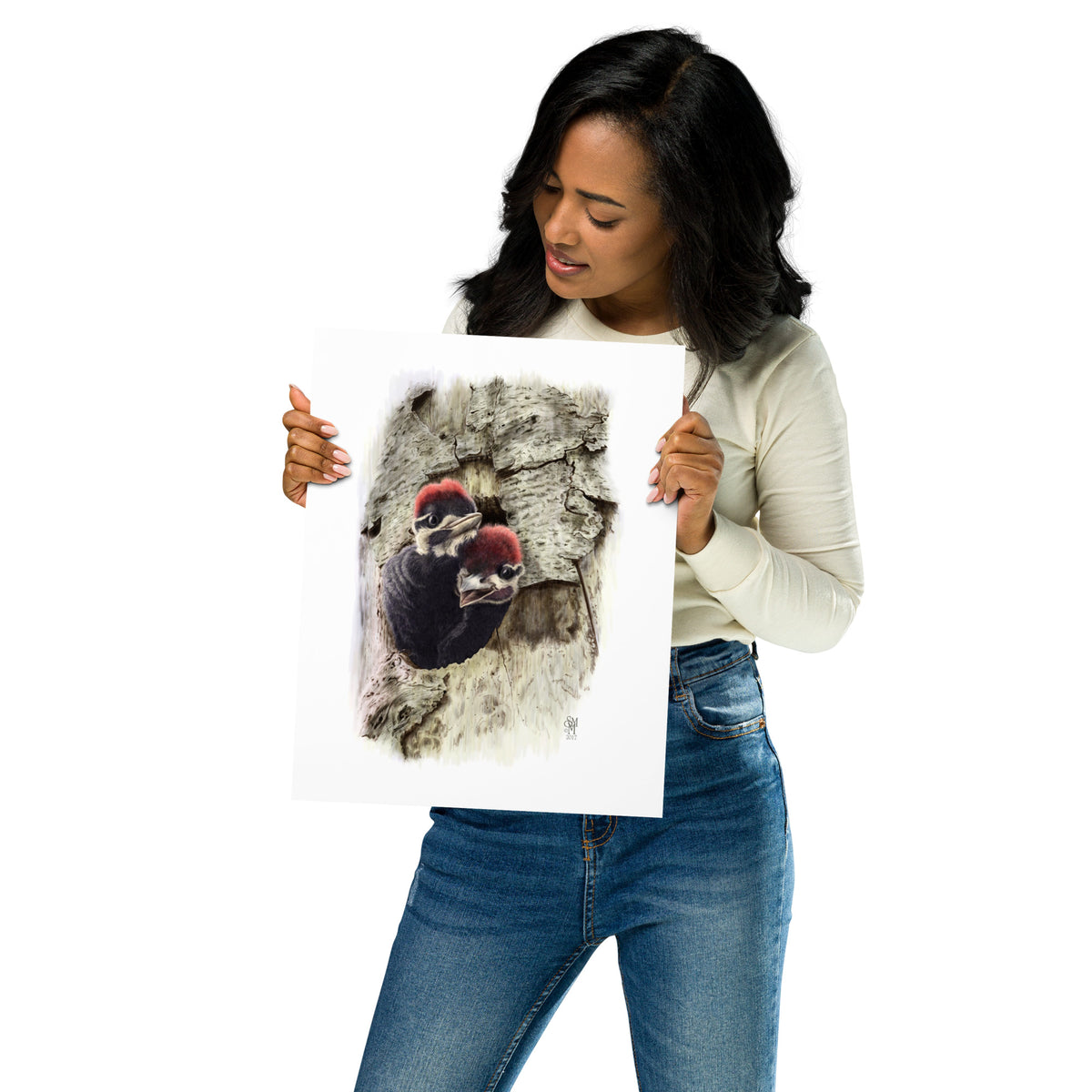 Person holding 11x14 inch museum-quality print of Two at the Door illustration of Pileated Woodpeckers to show relative size. Illustrated by Suzanne Matheson, 2017.